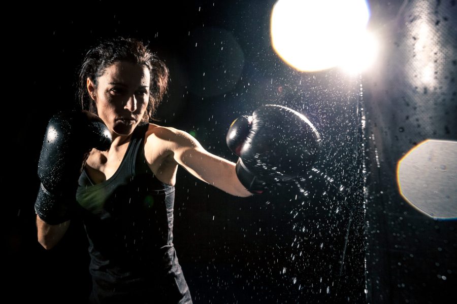 Young woman boxing at the punching bag