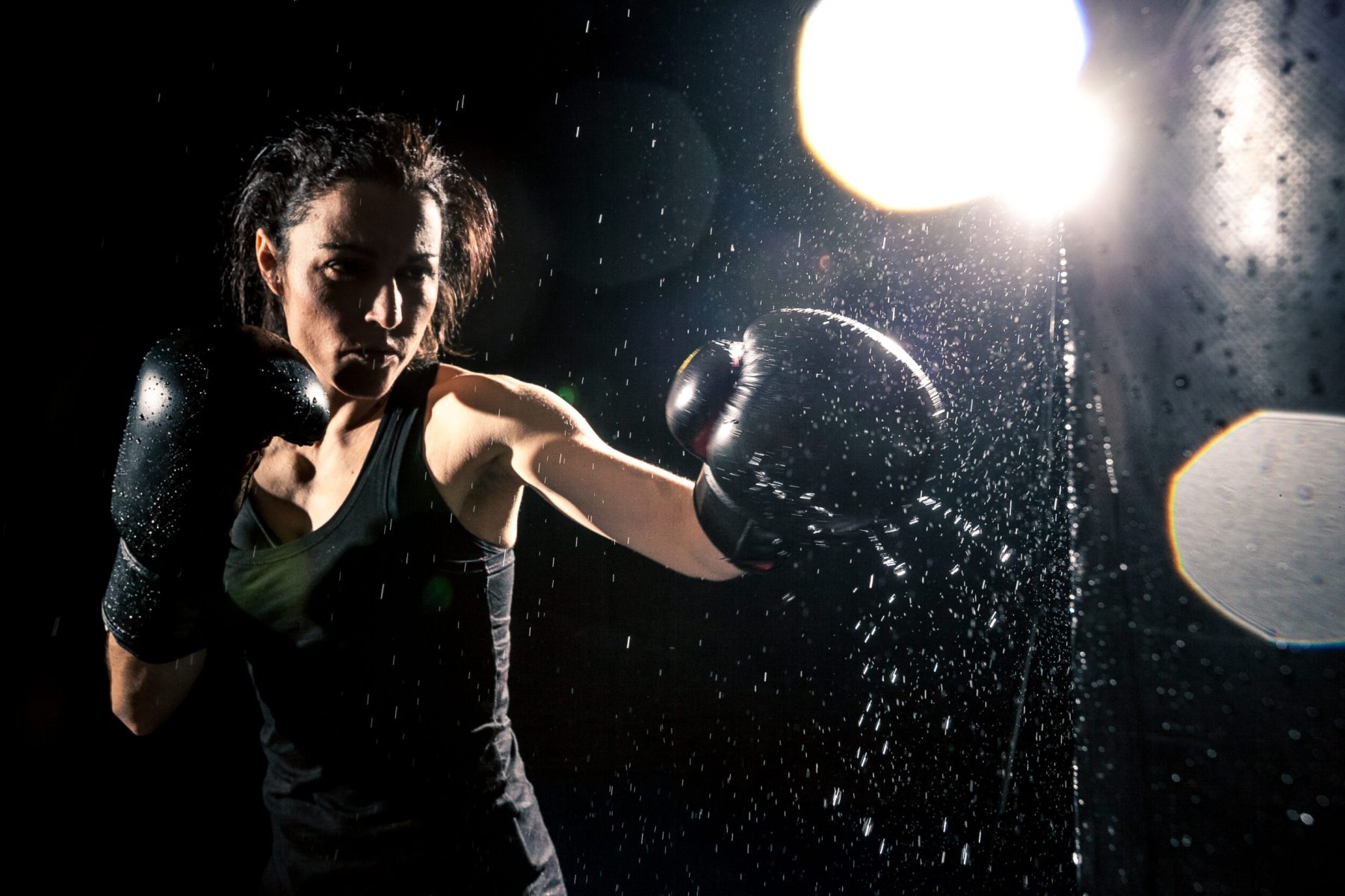 Young woman boxing at the punching bag